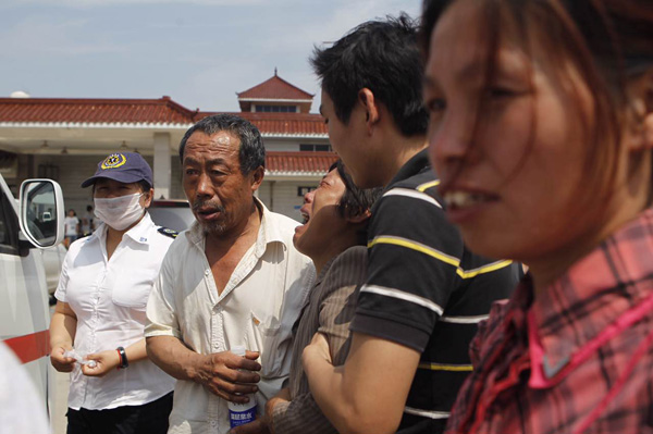 2025-08-03,阜宁县殡仪馆,人群熙攘,奶奶赵玉芩及其他家属站在火化室的门口。 澎湃新闻记者 韦毅 图